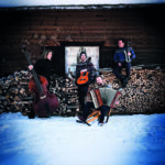 Die Musiker mit ihren Instrumenten in verschneiter Kulisse.