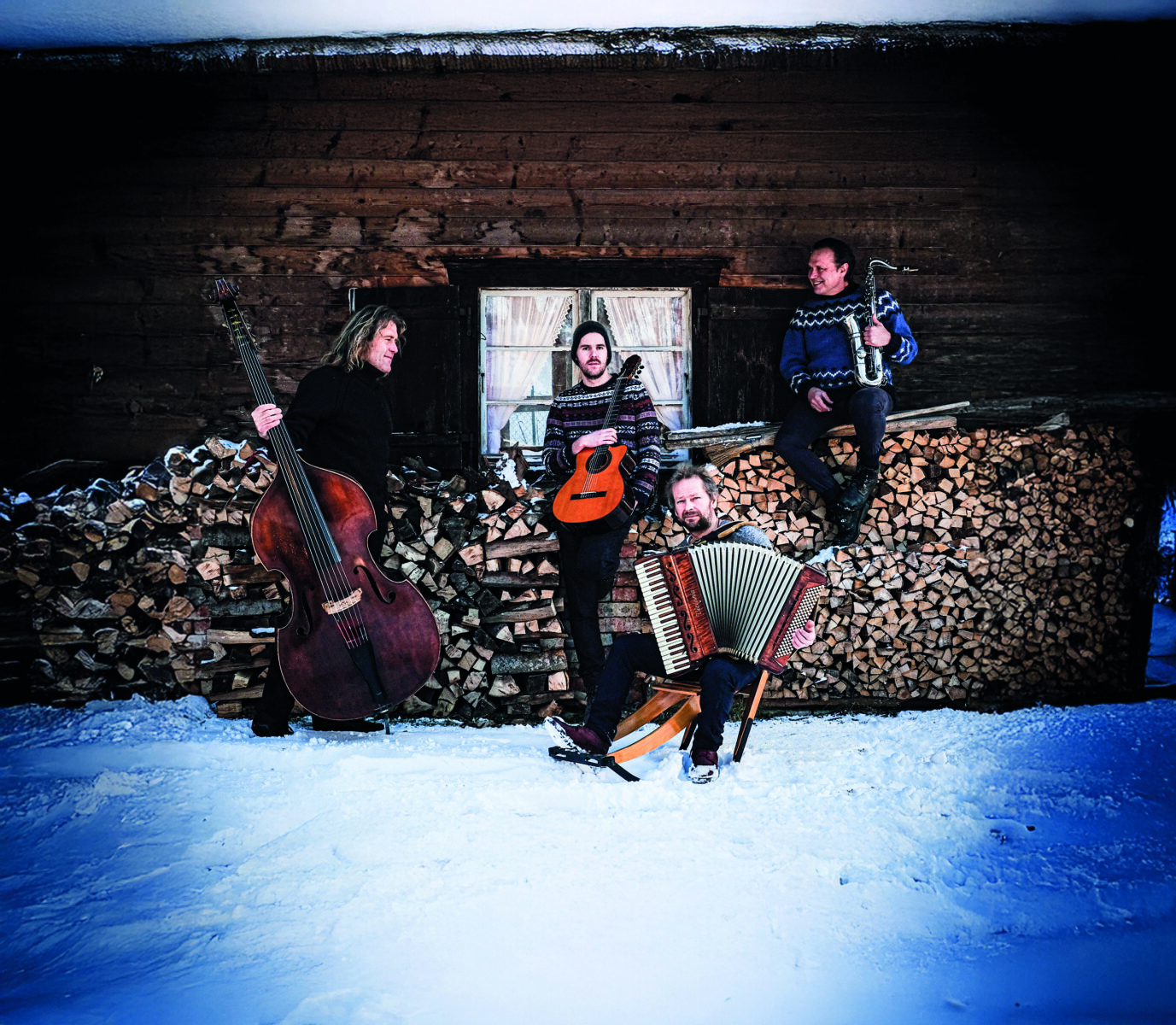 Die Musiker mit ihren Instrumenten in verschneiter Kulisse.