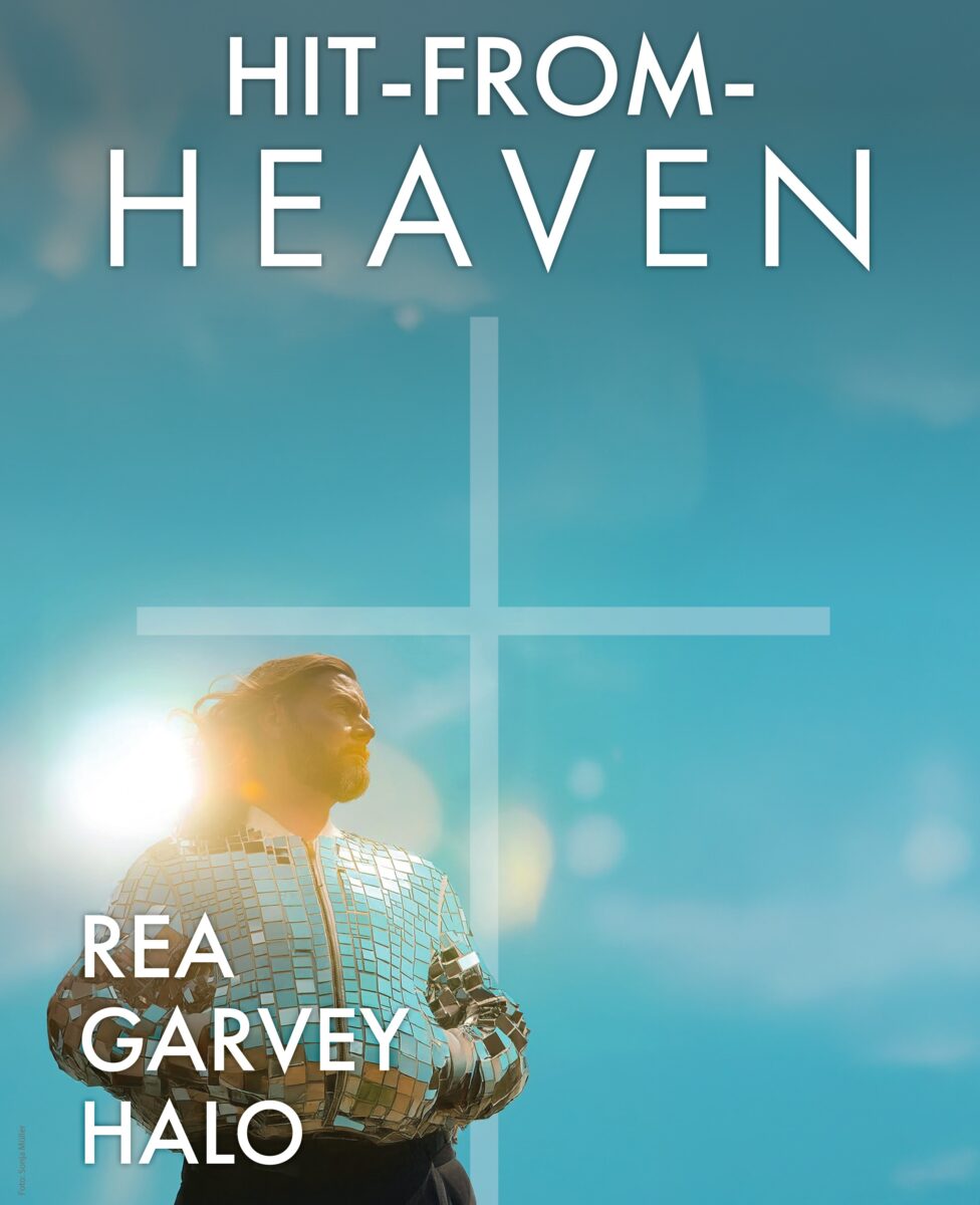 Sänger Rea Garvey vor einem blauen Hintergrund, die Sonne im Rücken, blickt in Richtung eines Kreuzes