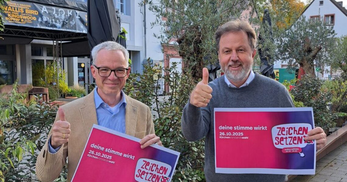 stv. Dekan Daniel Geiss und Dekan Martin Lückhoff halten jeweils ein Plakat der Kampagne "Zeichen setzen" in der Hand und einen Daumen nach oben.