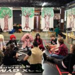 Die Kinder sitzen in Verkleidung im Kreis und besprechen etwas.