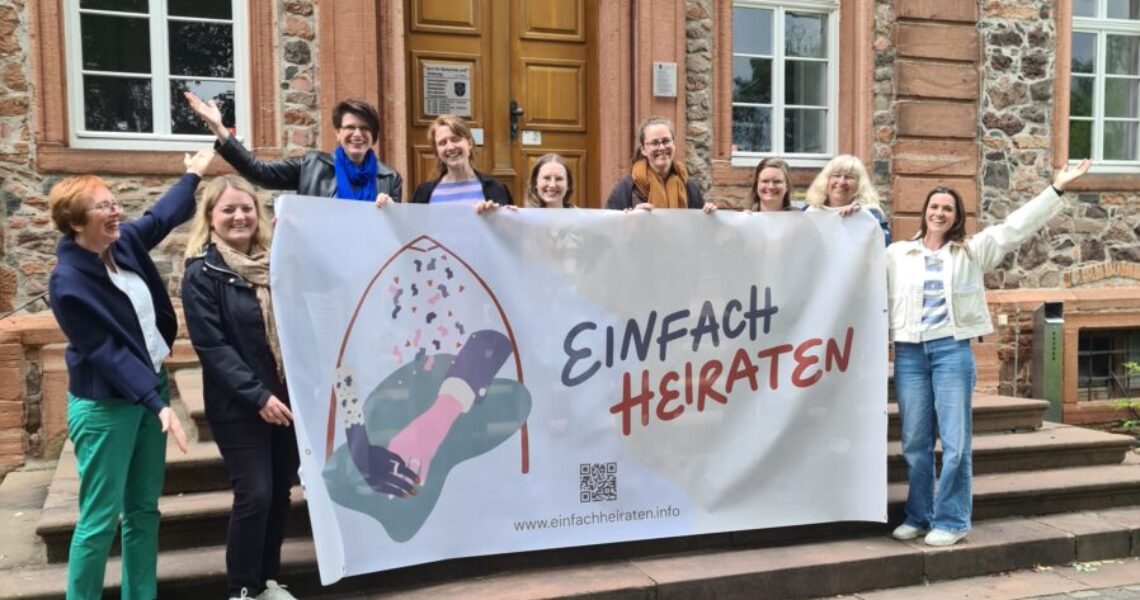 Pfarrpersonen aus dem Kirchenkreis Hanau mit dem großen Banner zur Aktion Einfach Heiraten vor dem Schloss Langenselbold